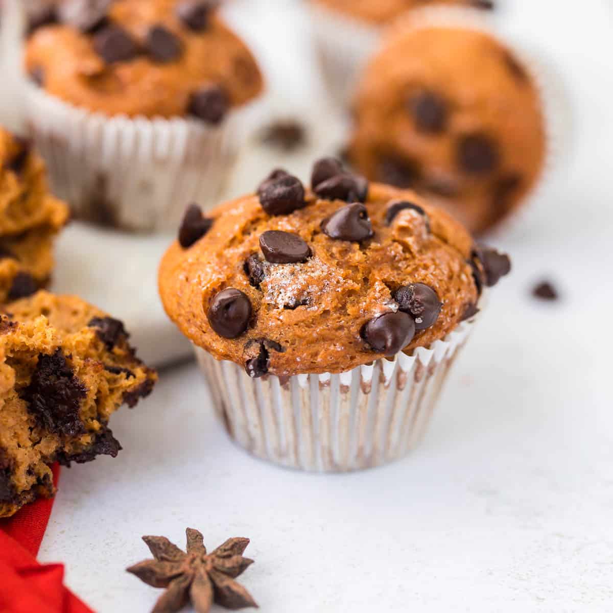Healthy Chocolate Chip Pumpkin Protein Muffin on white plate with broken piece beside to show texture