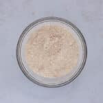 Flour, pumpkin pie spice, cinnamon, baking powder, and baking soda mixed in a bowl