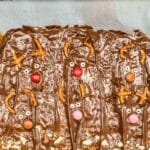 candy pieces added to melted chocolate layer to create reindeer faces for the toffee