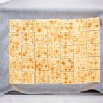 saltine crackers laid out in an even layer on parchment lined baking sheet for reindeer toffee
