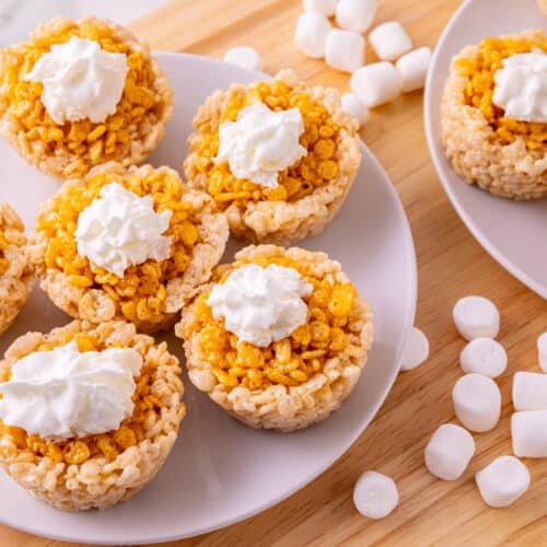 Pumpkin Rice Krispie treats shaped like mini pumpkin pies topped with whipped cream