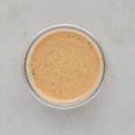 Creamy pumpkin overnight oats in a container with chia seeds stirred in before chilling in the refrigerator.
