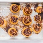 Freshly baked pumpkin cinnamon rolls with golden edges and visible cinnamon swirls