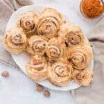 Homemade pumpkin cinnamon rolls topped with cinnamon cream cheese frosting, ready to serve